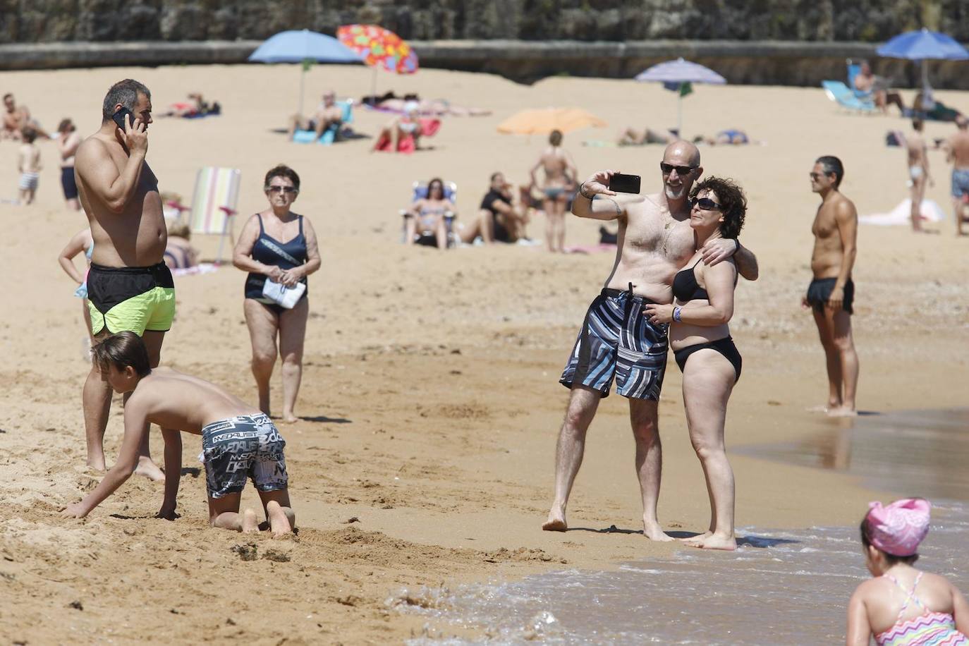 Aspecto que presentan este sábado las playas de El Sardinero y de la bahía de Santander, con muchos bañistas, gente paseando por la orilla, disfrutando del mar y tomando el sol.