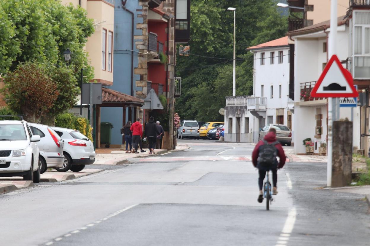 Un grupo de vecinos paseaba ayer por El Puente de Guriezo, mientras un joven circula en bicicleta. a. verano