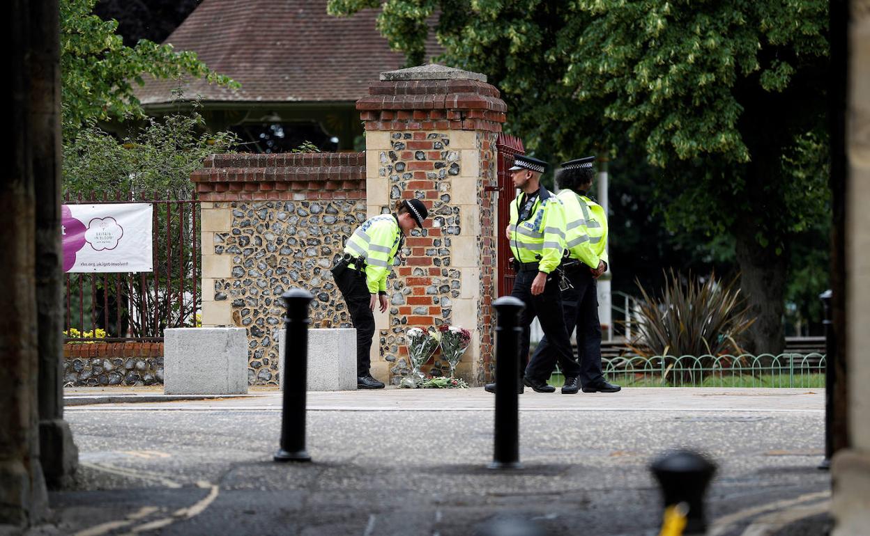 Los policías colocan flores en recuerdo de las víctimas del ataque de Reading, en el exterior del parque donde tuvieron lugar los hechos.