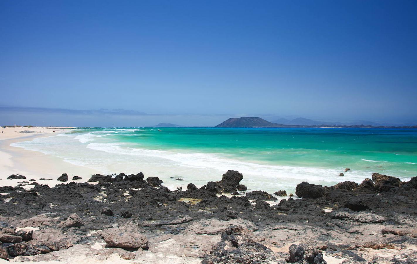 Parque Natural Islote Isla de Lobos (Fuerteventura) | Este Parque Natural es una isla volcánica que se encuentra a pocos kilometros del Puerto de Corralejo en Fuerteventura y apenas a 8 km de Lanzarote, en el Estrecho de Bocayna. Su nombre viene de la abundancia de Focas Monje (Lobos Marinos) que habitaban estas aguas hace unos 500 años. El parque ocupa la totalidad de esta isla, en la que encontrarás tranquilidad, aguas cristalinas y paisajes volcánicos de enorme belleza.