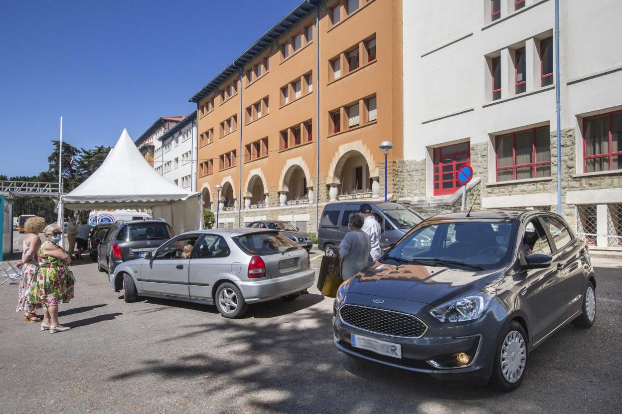 Coches a la espera de pasar por la carpa del 'coroauto' instalado en el Hospital de Liencres, donde son frecuentes las colas. 