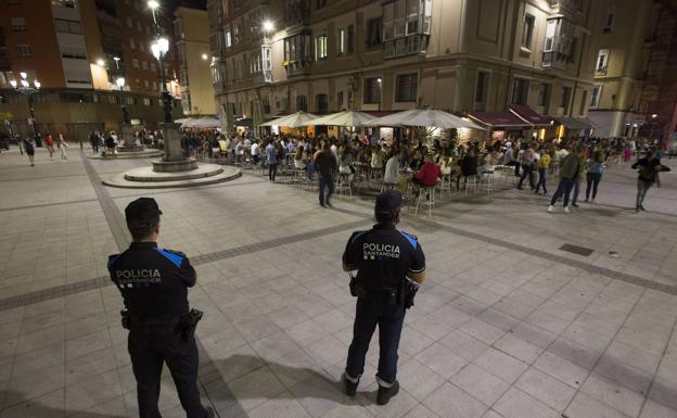 Dos agentes de la Policía Local de Santander vigilan desde una prudencial distancia el curso de la noche en la Plaza de Cañadío. 