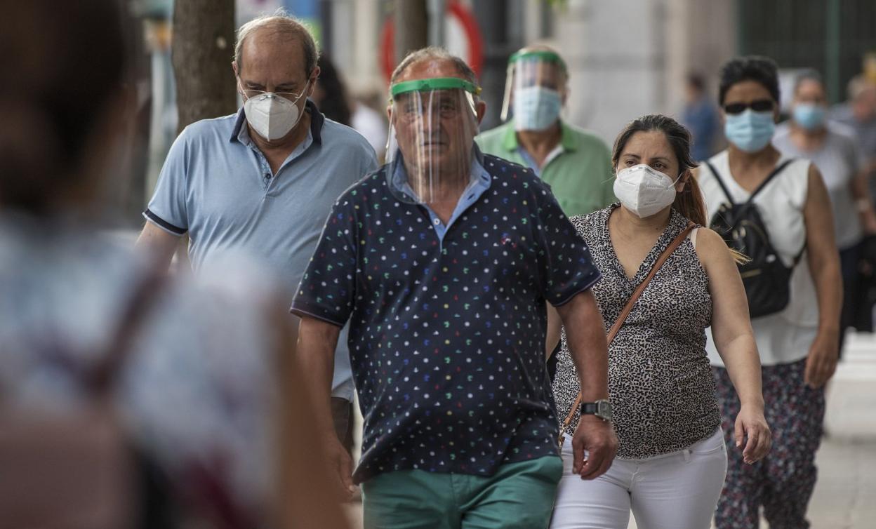 Viandantes protegidos con mascarillas por las calles de Santander. MARÍA GIL LASTRA