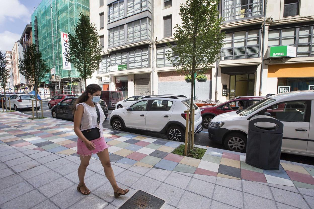 Una viandante pasea por la renovada calle Magallanes, en el entorno de La Florida, con nuevos y coloridos adoquines.