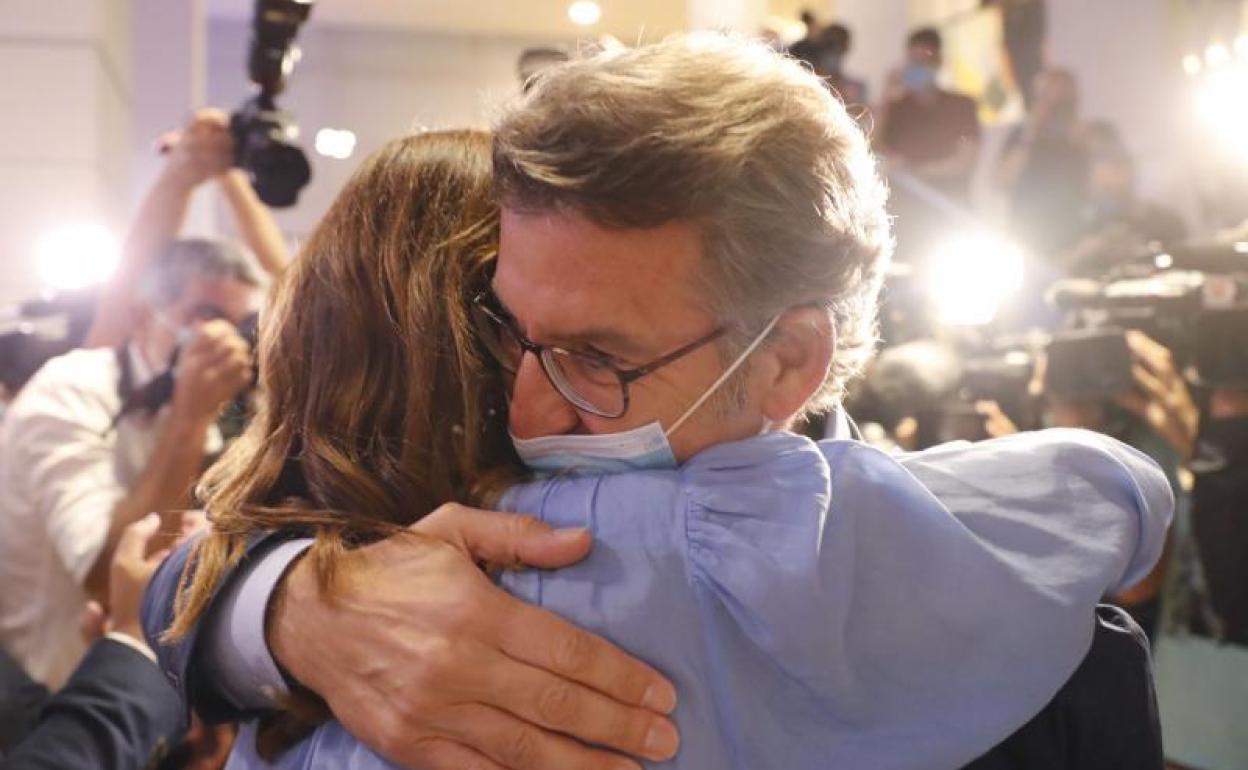 Alberto Núñez Feijóo se abraza, anoche, a su mujer tras su cuarta victoria en Galicia.