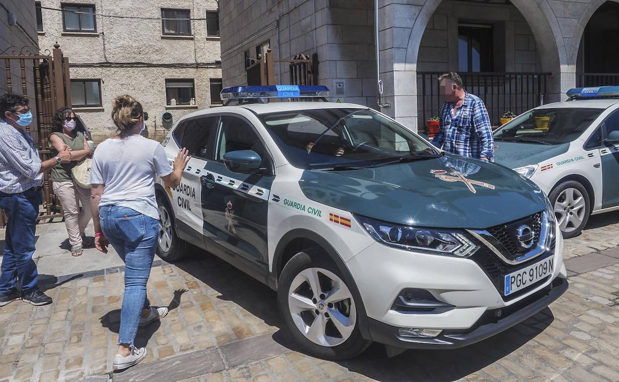 Un coche de la Guardia Civil traslada a los jóvenes detenidos para declarar ante el juez, mientras son despedidos por unos familiares.