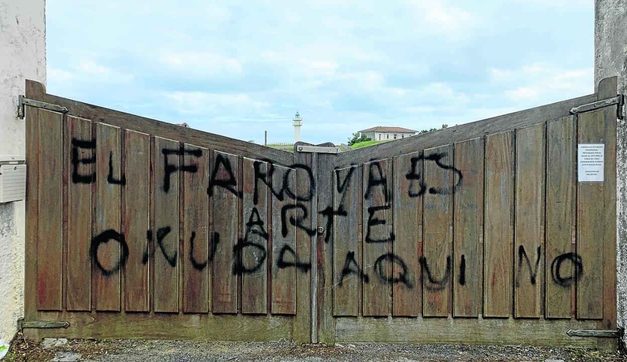 La puerta de entrada a la finca del faro de Ajo exhibe desde hace unos días un mensaje en contra del proyecto de pintarlo. sane