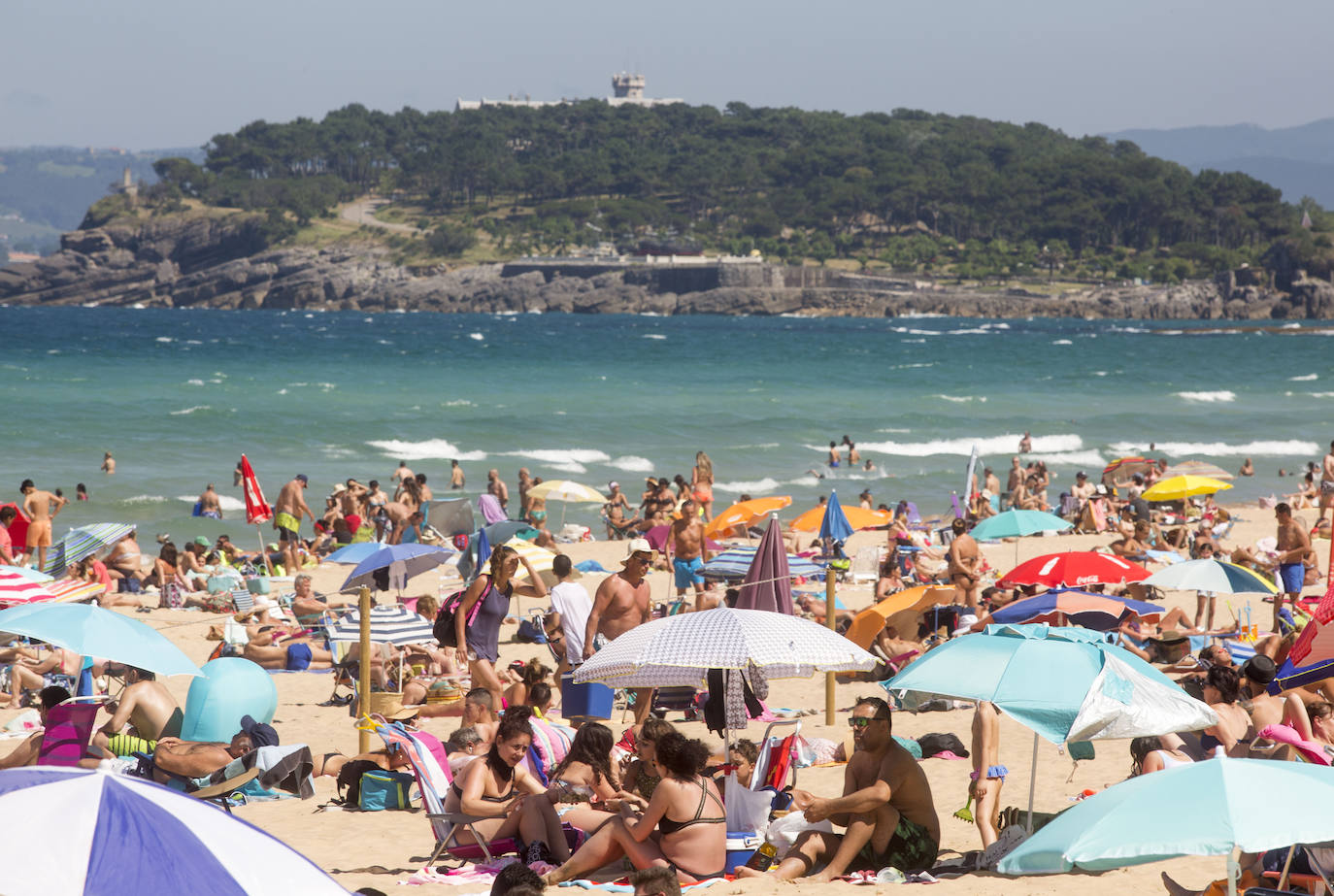 Cientos de bañistas han disfrutado este sábado de las playas de El Sardinero, en una jornada plenamente veraniega marcada por el uso obligatorio de la mascarilla y la restricción de los aforos. En algunos momentos, algunos de los arenales colgaron el cartel de 'completo'.