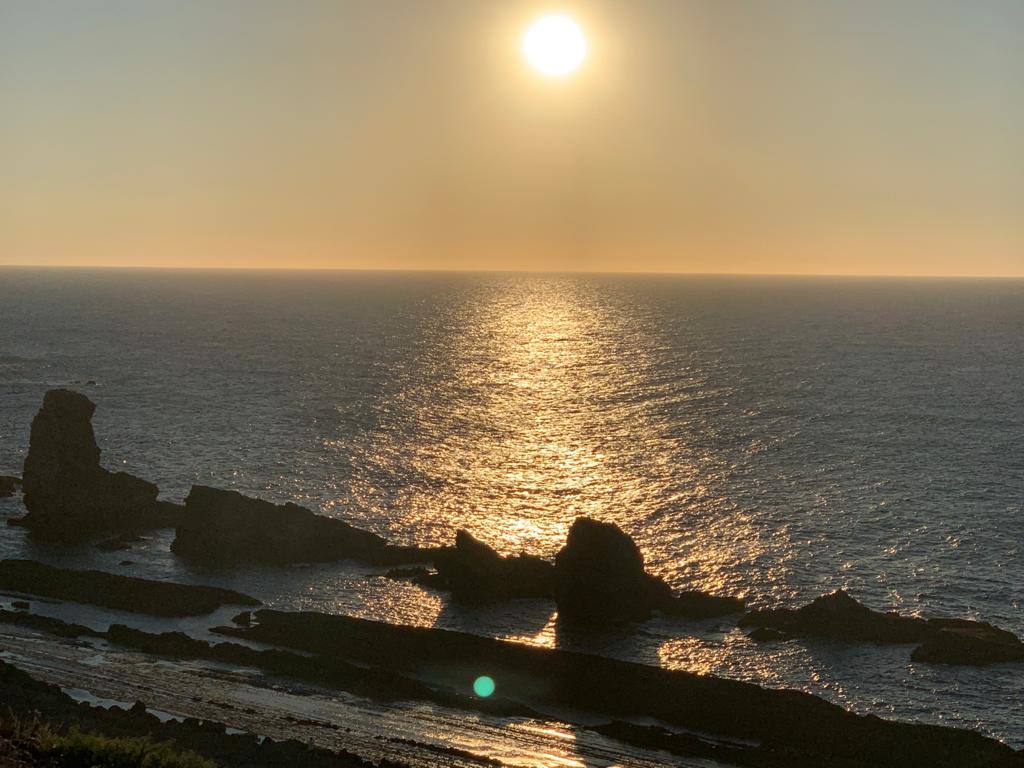 Numerosas personas, muchas de ellas con mascarillas y guardando las distancias, se congregaron ayer en los acantilados de la playa de La Arnía (Piélagos) para contemplar la puesta de sol. Un maravilloso espectáculo que regala la naturaleza en Cantabria.