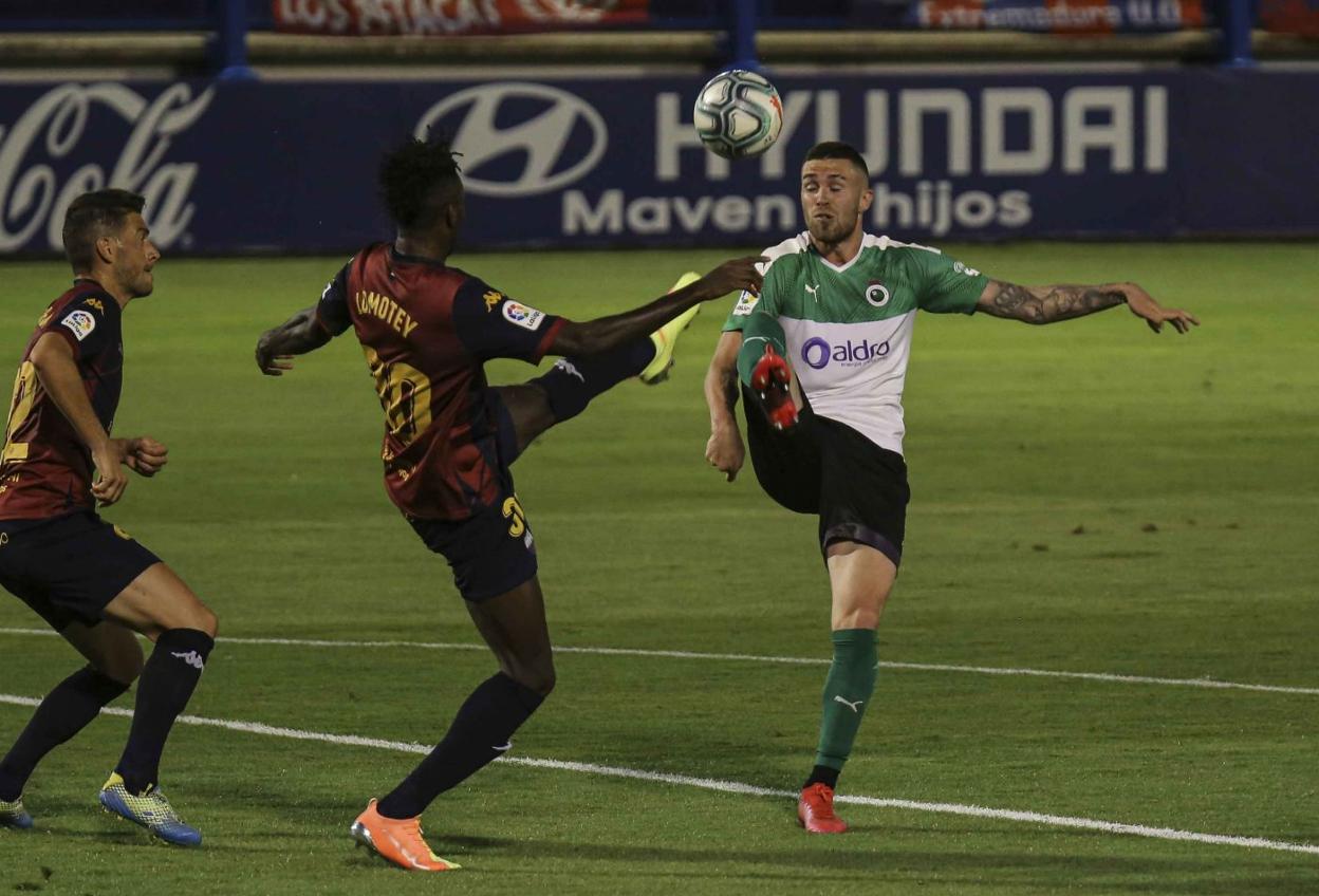 Manu Hernando despeja el balón ante Lomotey en el partido frente al Extremadura en Almendralejo. lof