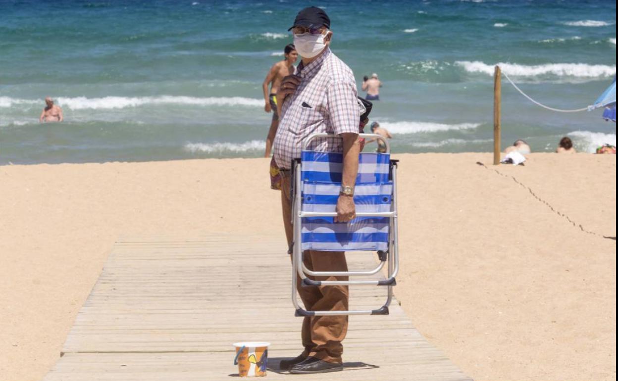 Un bañista en El Sardinero con mascarilla.