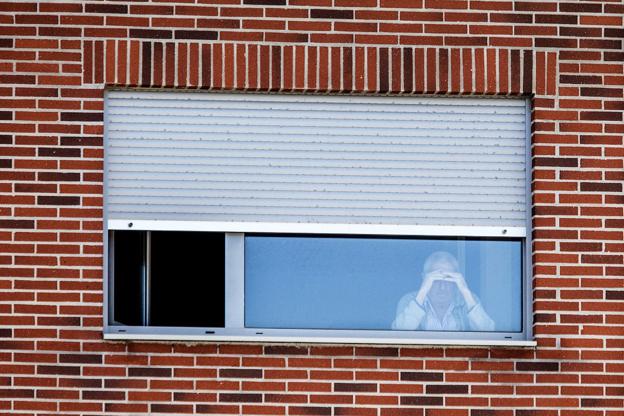 Uno de los usuarios de la residencia de Liencres se acerca a la ventana de su habitación para ver la calle. 