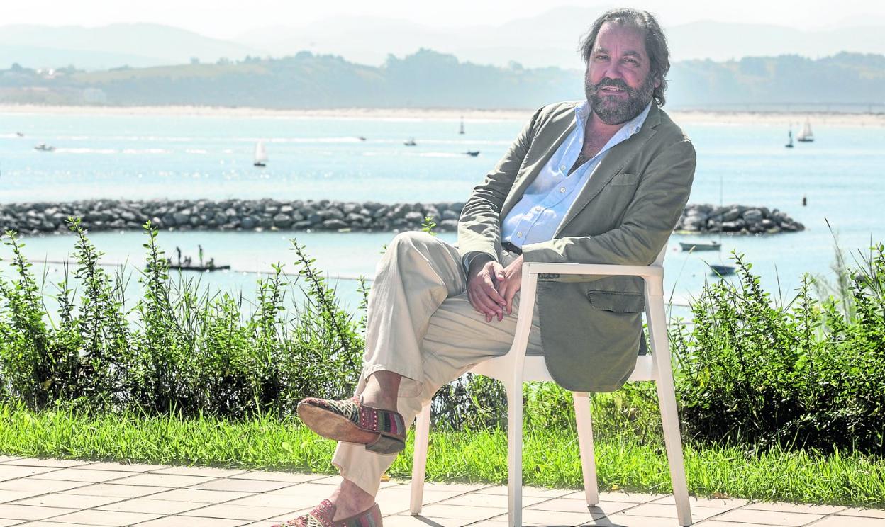 Ramón Pérez-Maura, en el porche de su casa, con la escollera de la playa de La Magdalena, al fondo. 