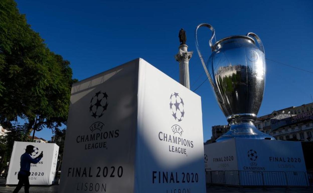 Un aficionado saca fotografías junto a una réplica gigante del trofeo de la Liga de Campeones que se exhibe en la Plaza del Rossio de Lisboa. 