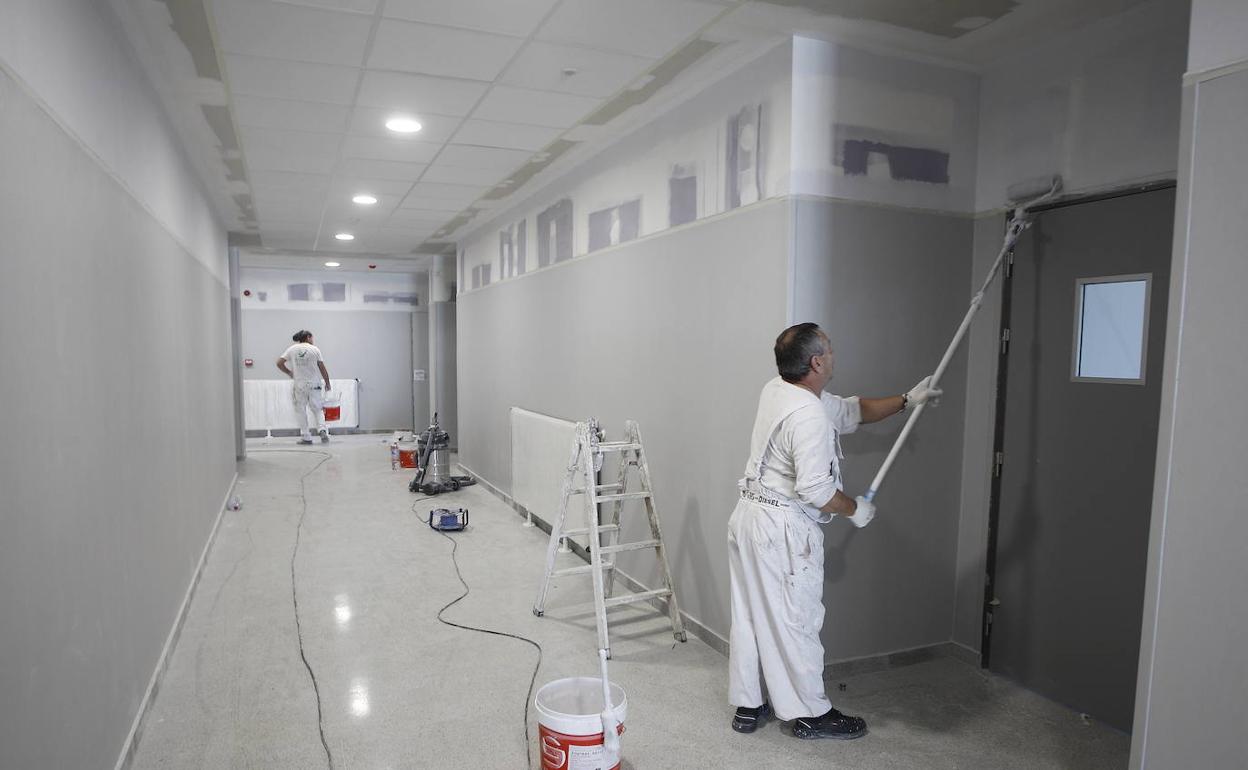 Dos operarios realizan trabajos de pintura en las nuevas instalaciones del IES Zapatón.