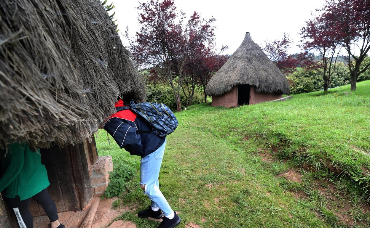 Dos personas entran en una de las cabañas del Poblado Cántabro de Cabezón de la Sal. Javier rosendo