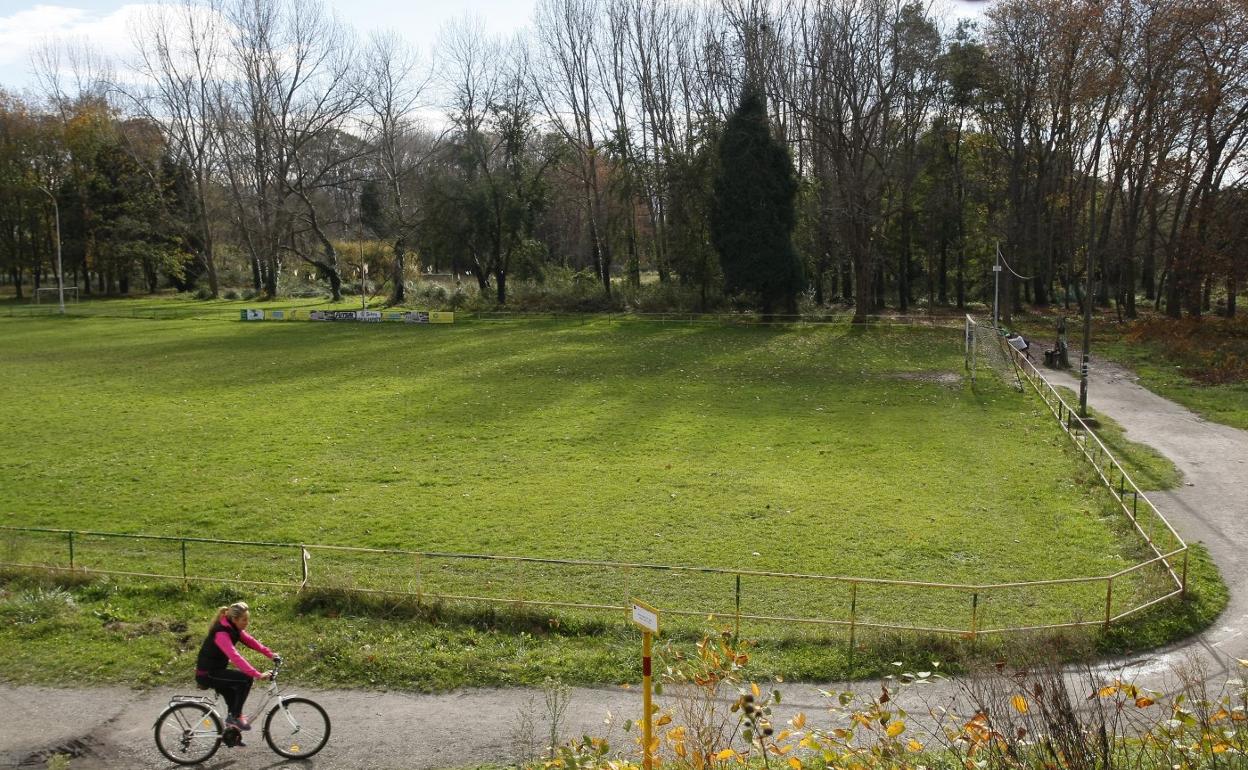 Una mujer pasea en bicicleta por El Patatal, donde se desarrollan diversas actividades deportivas.