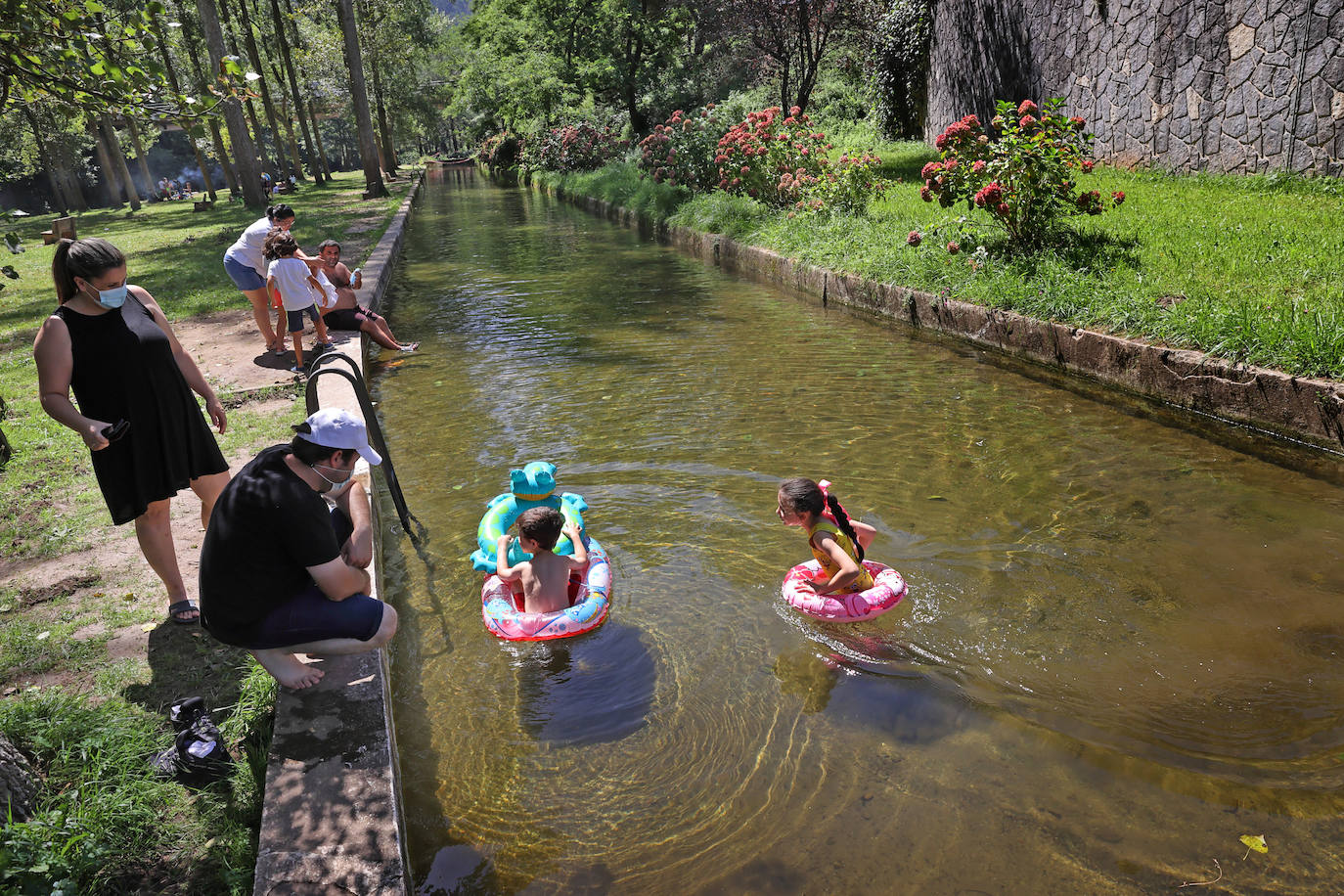 Los cauces y pozos son más que nunca un reclamo para los turistas estos días de calor, unos espacios que comparten con los vecinos. En estas imágenes, niños y mayores disfrutan en el río Saja, en el parque de Santa Lucía de Cabezón de la Sal.