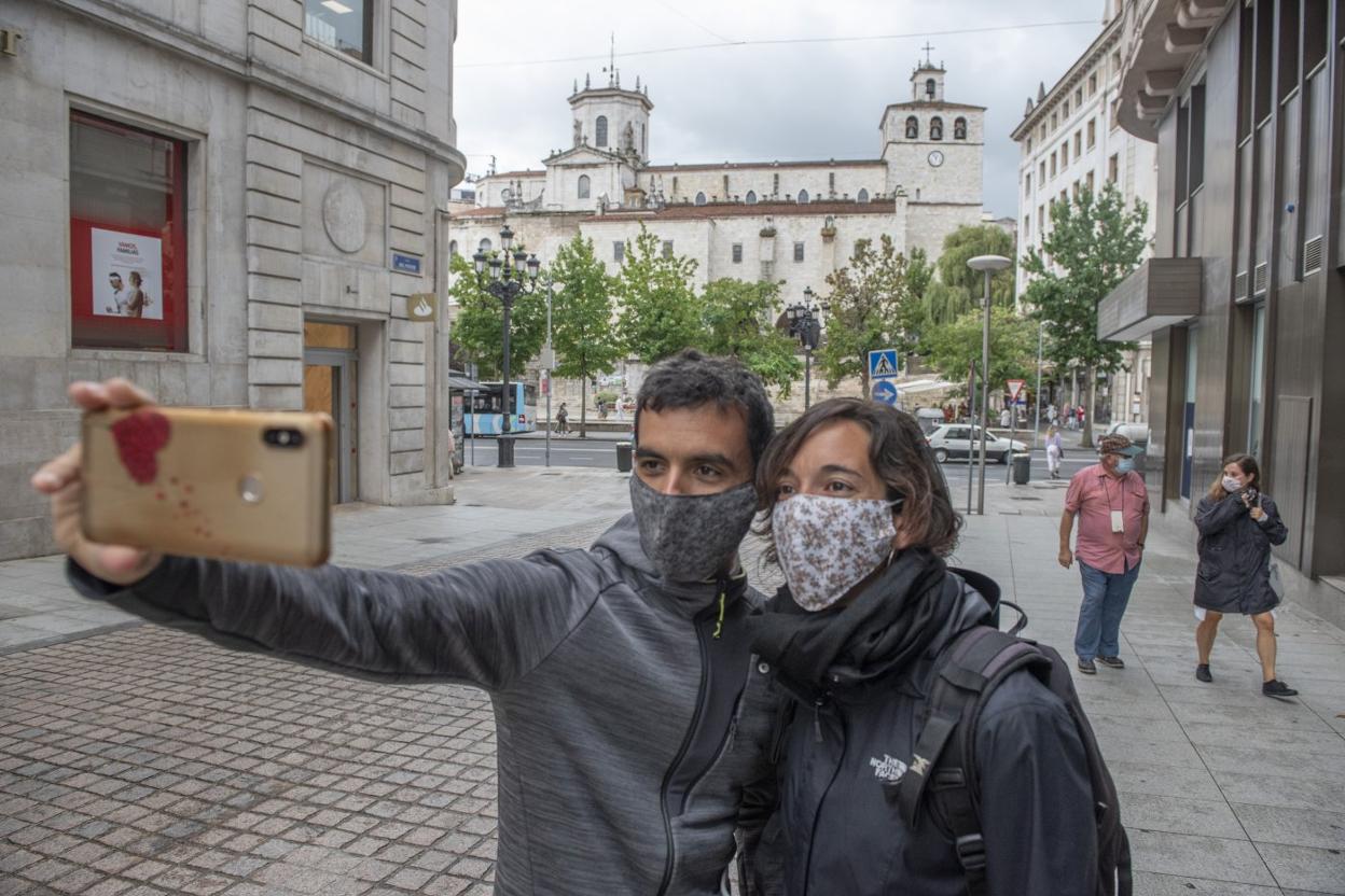 Una pareja de turistas, ayer por Santander, se saca una fotografía con la catedral de fondo. maría gil