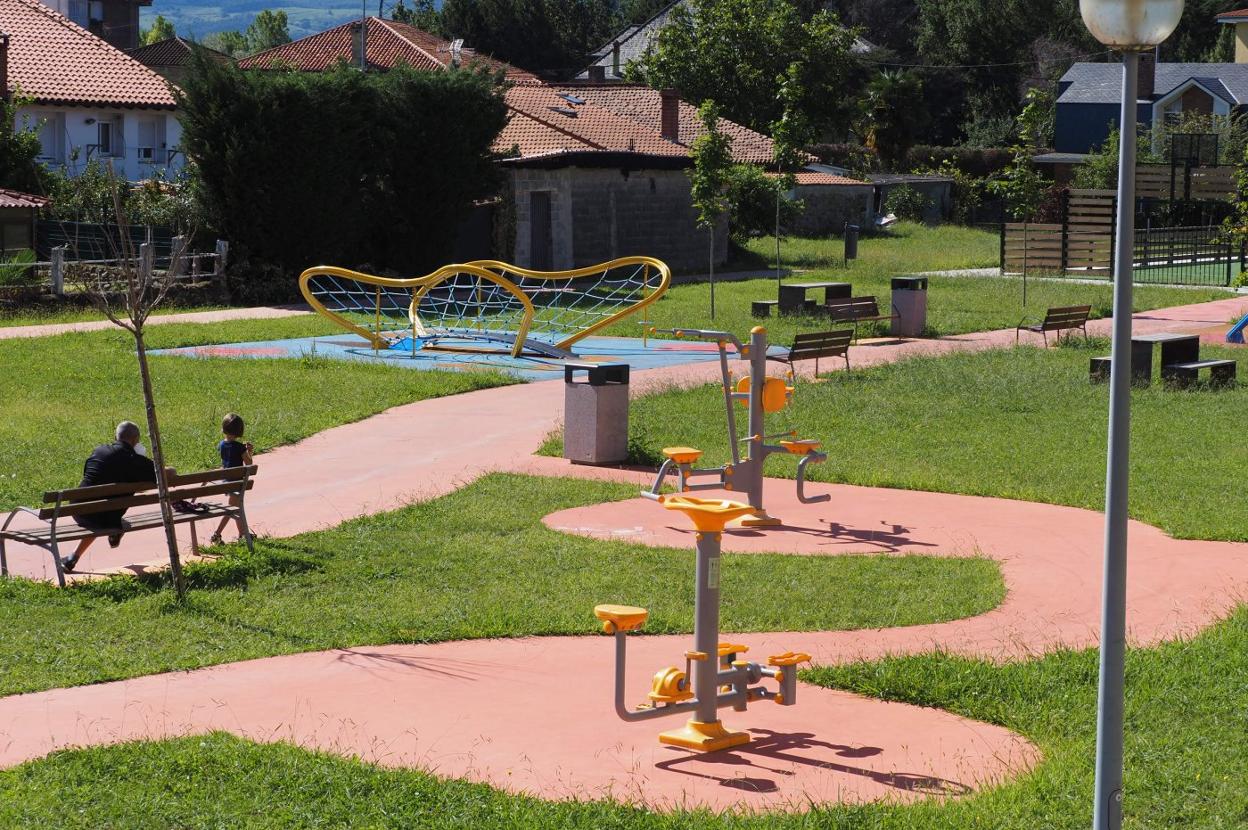 Un vecino y su nieta disfrutan del nuevo parque municipal en el centro de la localidad de Ganzo. 