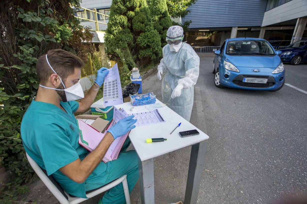 Dos sanitarios trabajan en el 'coroauto' de la Facultad de Medicina, en Santander. 