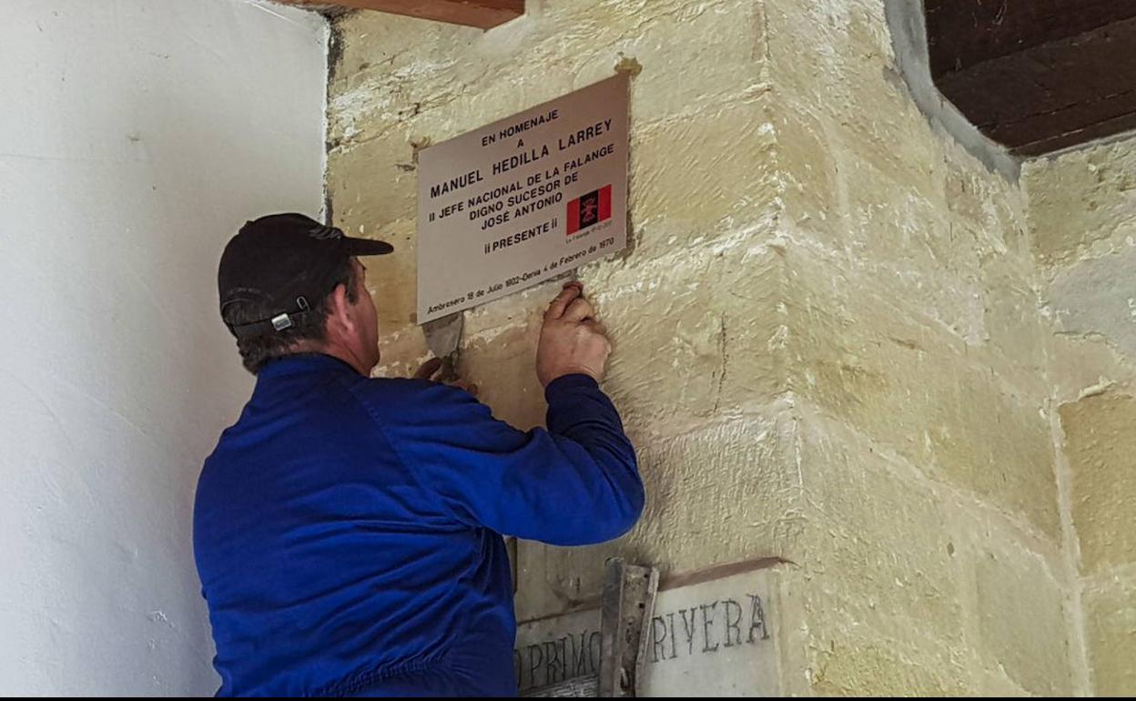 Imagen de archivo de la retirada en enero de 2018 de la placa falangista aparecida en el pórtico de la iglesia de San Andrés de Ambrosero, en homenaje al político falangista Manuel Hedilla Larrey.