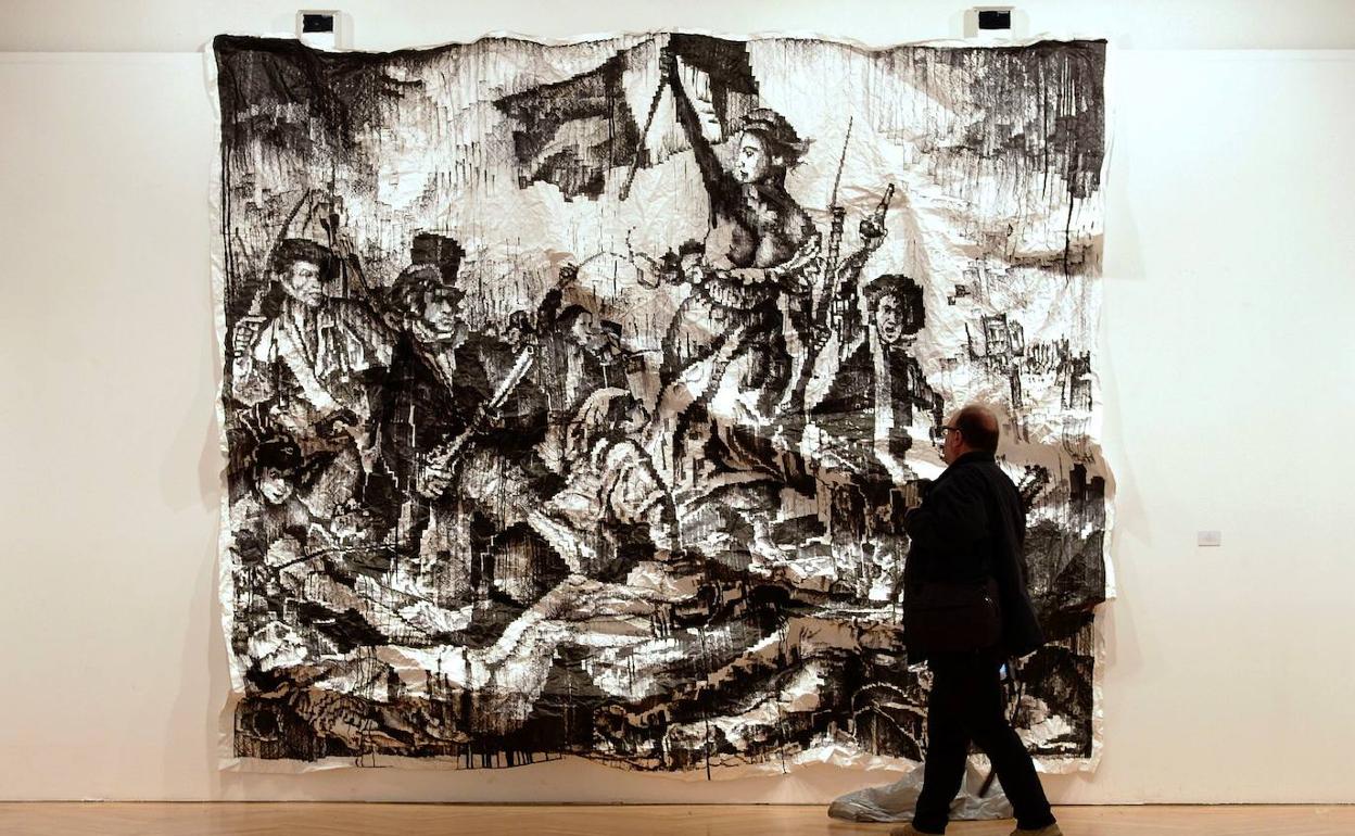 Un hombre observa la obra de Javier Arce de su serie 'estrujados', integrada en Los Bragales. 
