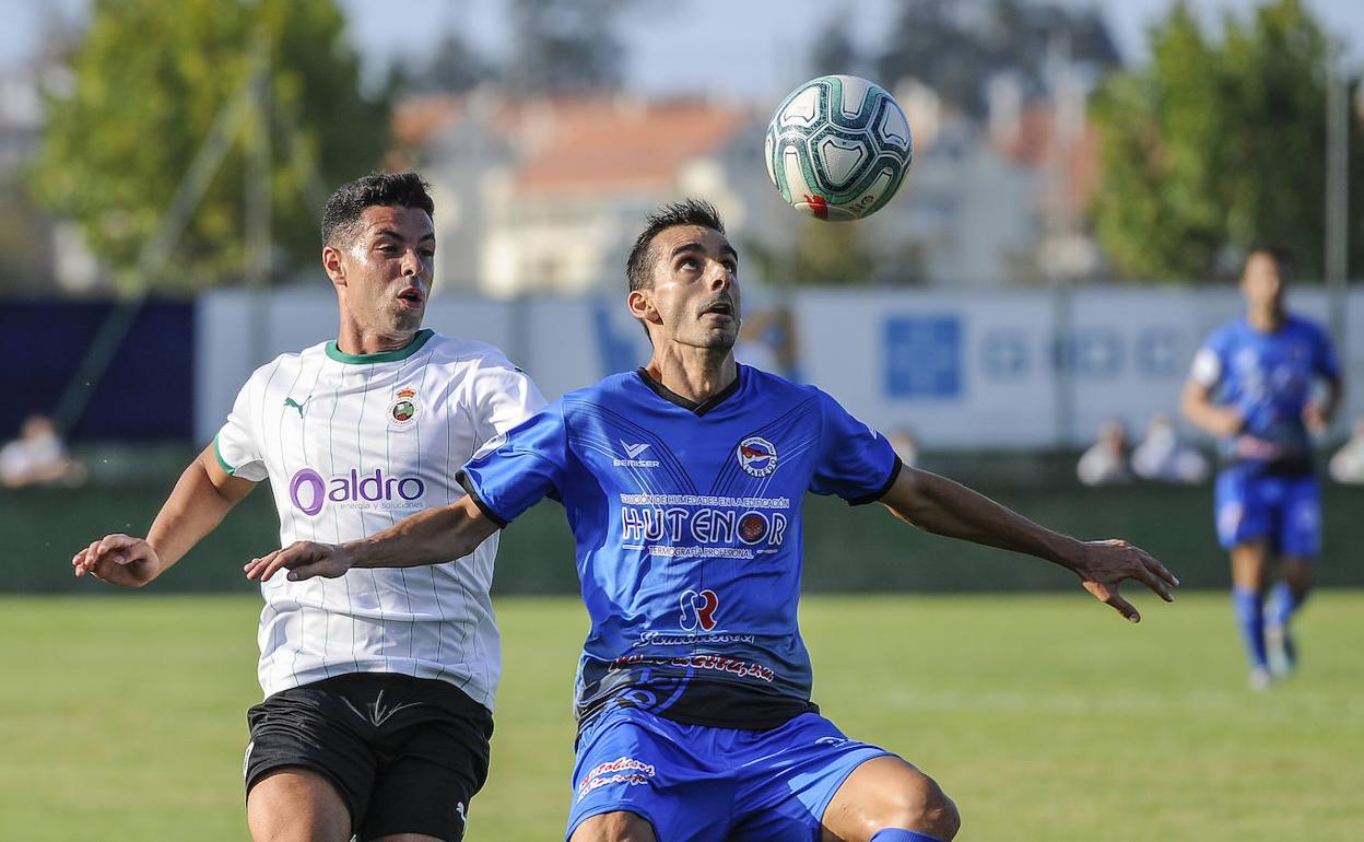 Riky intenta controlar el balón en presencia de Álvaro Bustos en el amistoso Laredo-Racing. 