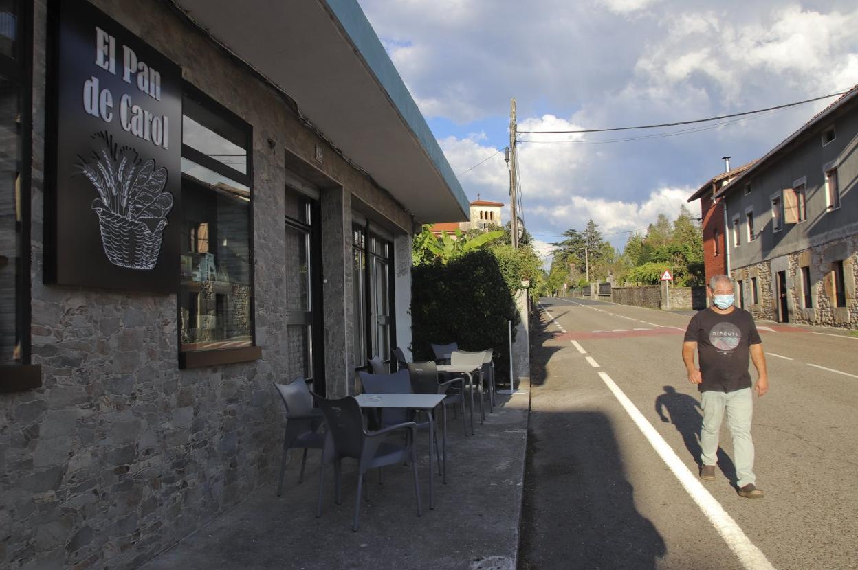 Un vecino de Valle de Villaverde pasea por delante de El Pan de Carol, un establecimiento que ha abierto recientemente. a. verano