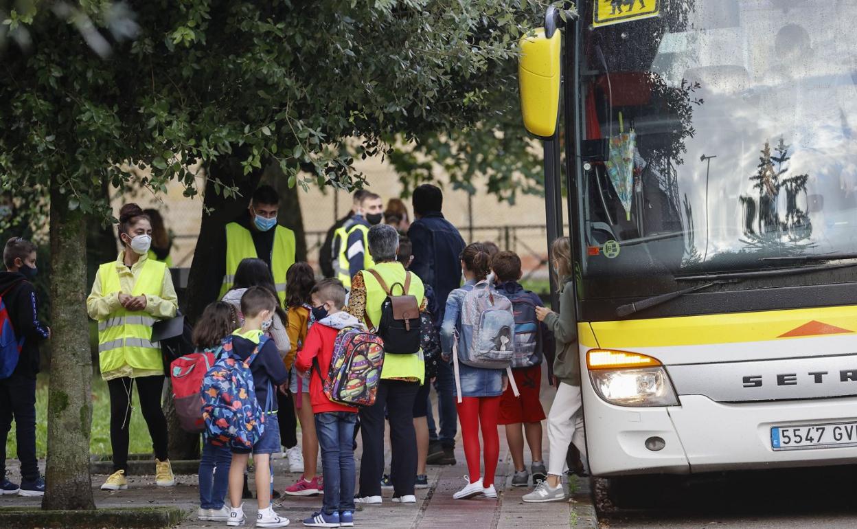 Un grupo de escolares baja del autobús para dirigirse a clase