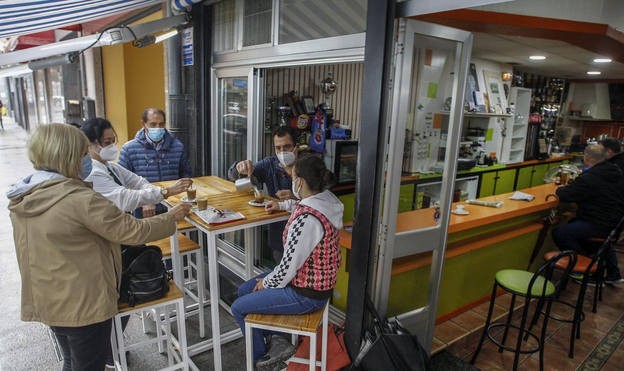 Varios vecinos toman un café en un establecimiento de la calle Juan XXIII, que ayer volvió a abrir sus puertas tras catorce días de confinamiento. 