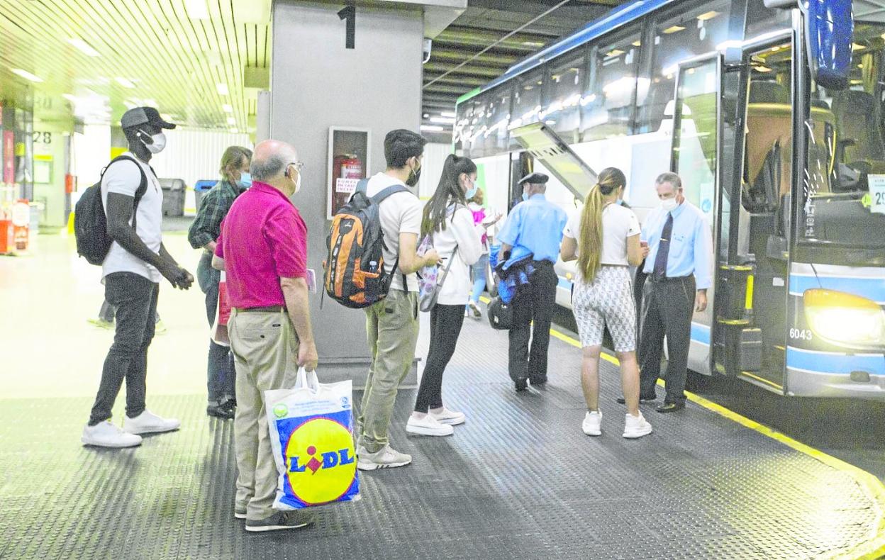 Un grupo de pasajeros hace cola para subir a un autobús en la estación de Santander. 