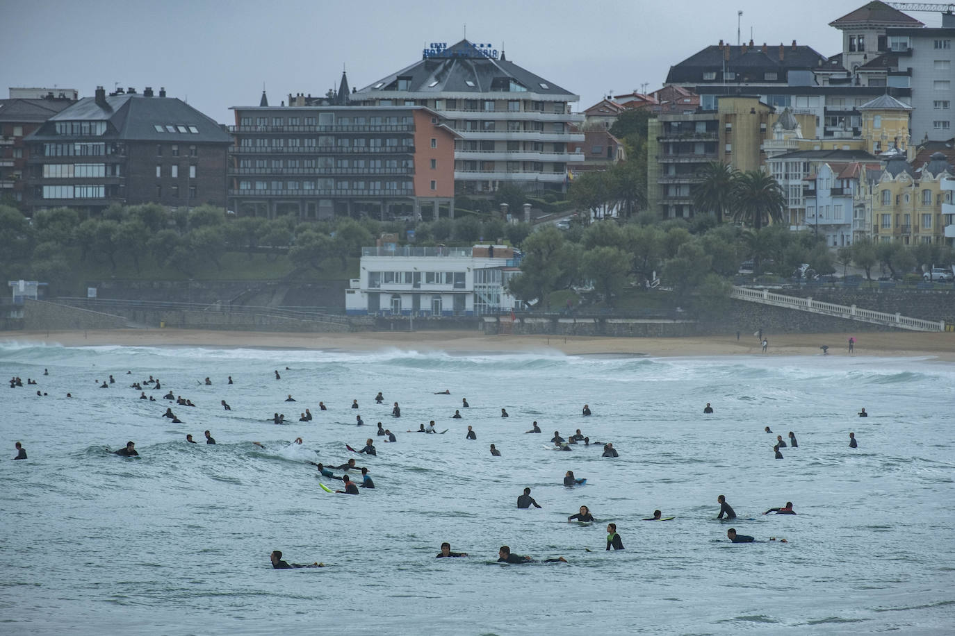 Llueve incesantemente en Cantabria y también hay grandes olas, que aprovechan los surfistas para pintar una de las estampas más habituales de Santander cuando el mar está embravecido.