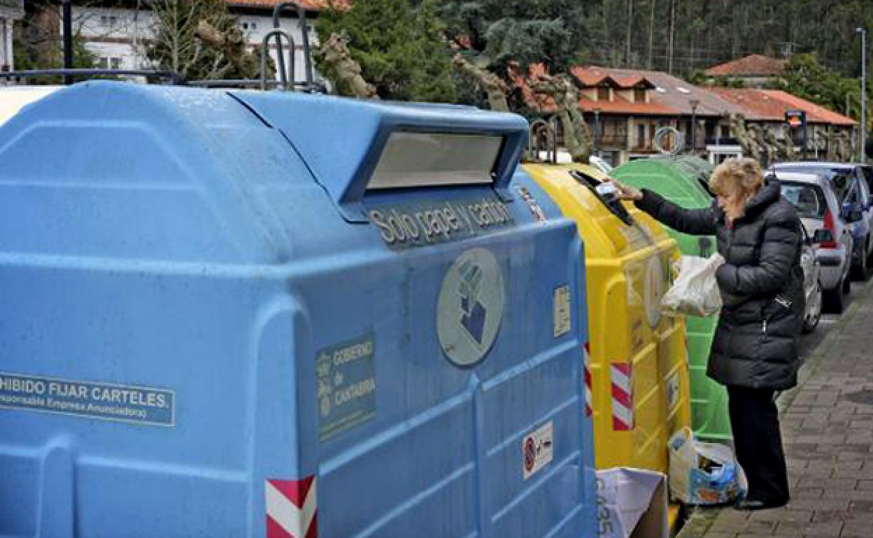 Señora en los cubos de reciclaje en Cabezón de la Sal.