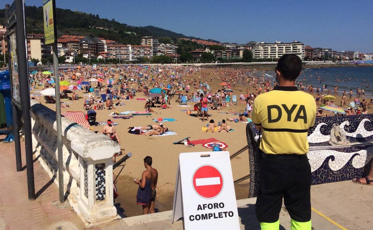 Un socorrista de la DYA revisa el aforo en la playa castreña.