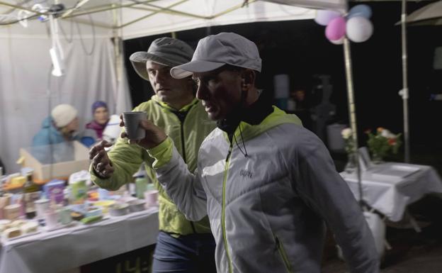 Un voluntario le da un café al italiano Andrea Marcato 