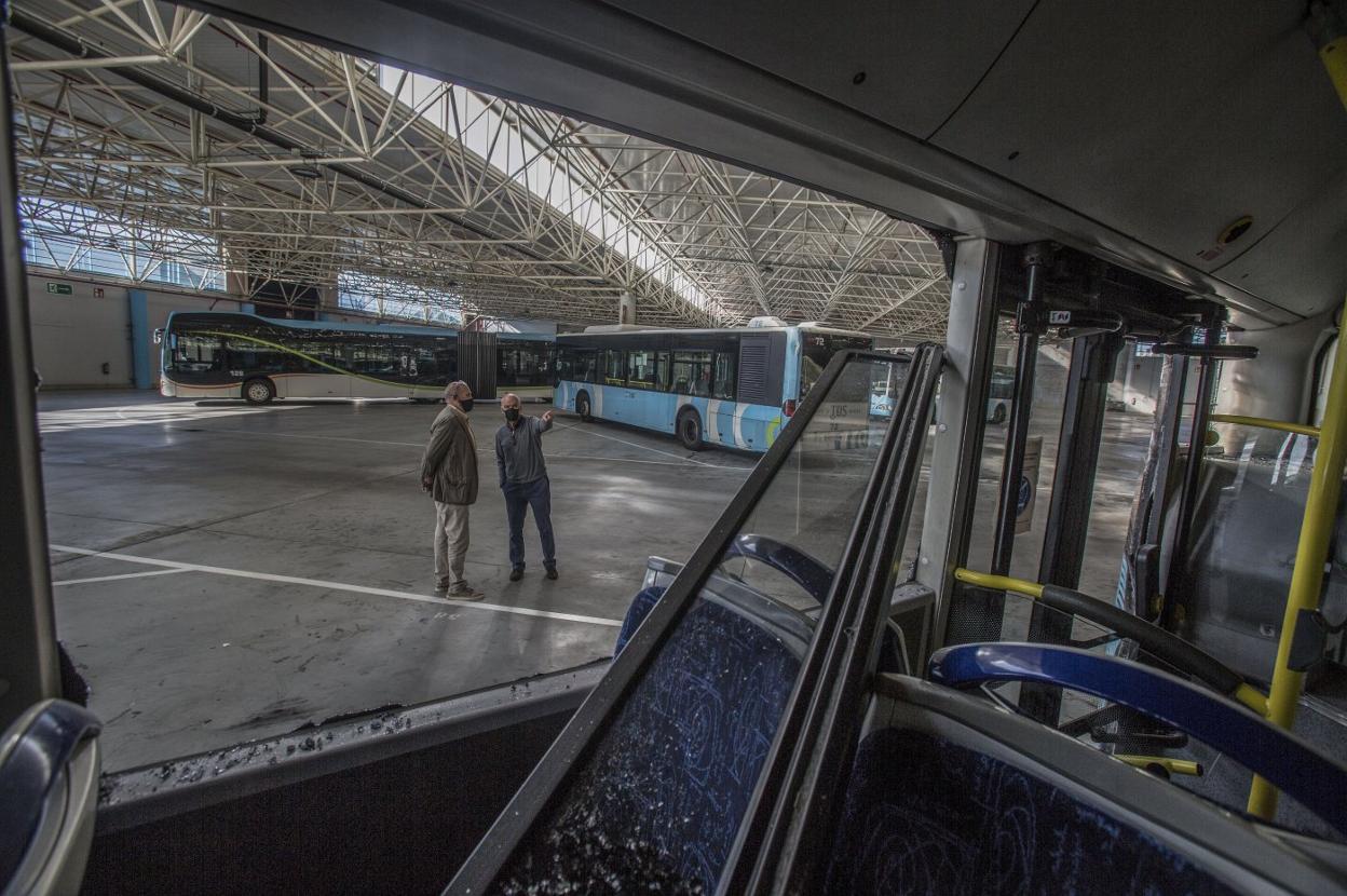 El arquitecto del edificio, Ramón Sáiz, y el gerente del TUS, José Ramón Fernández, señalan el autobús que se chocó el sábado. 