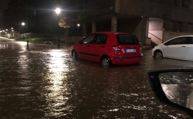 La carretera y los accesos a las viviendas de la zona de Cros inundados por la cantidad de lluvia caída