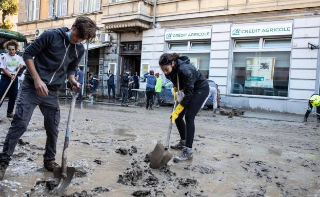 Un grupo de voluntarios retira el lodo de una calle en Ventimiglia.