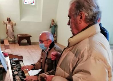 Imagen secundaria 1 - Arriba, un momento de la celebración del Día de El Pilar y abajo, el armonio de la parroquia y el tenor José Antonio Urdiaín. A su lado, el Cristo de la Expiración, de Manuel Cacicedo.