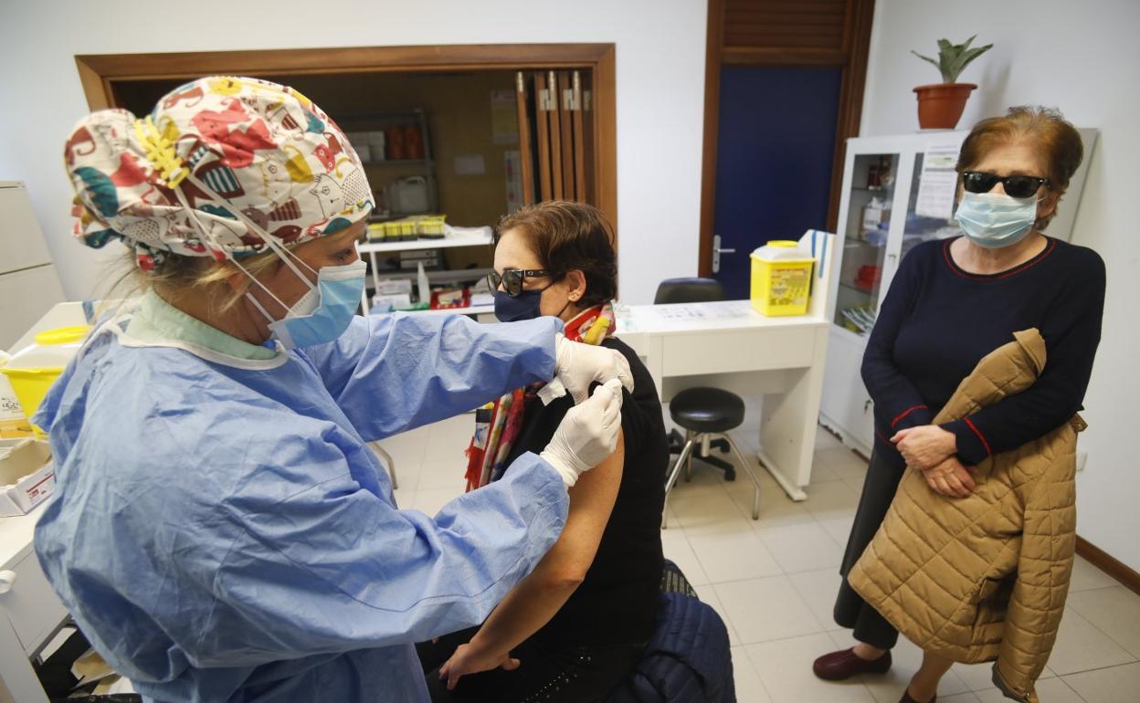 Una enfermera inyecta la vacuna contra la gripe a una mujer, ayer por la tarde, en el centro de salud de Puertochico