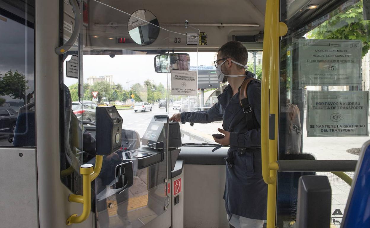 Un viajero pasa su tarjeta en un autobús municipal de Santander.