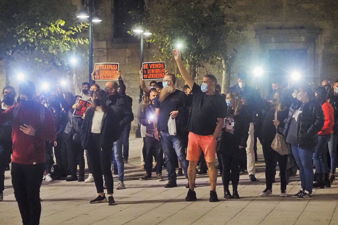 Decenas de trabajadores y empresarios de hostelería protestaron el sábado por la noche en la Plaza de Cañadío con carteles de 'se vende' y las linternas de sus móviles. También colocaron velas frente a la sede del Gobierno regional.