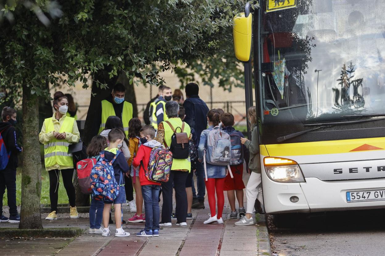 Un grupo de alumnos se dispone a subir al autobús escolar. 