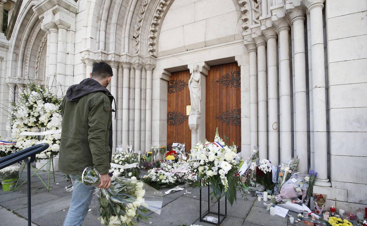 Un hombre deposita flores en la Basílica de Niza.