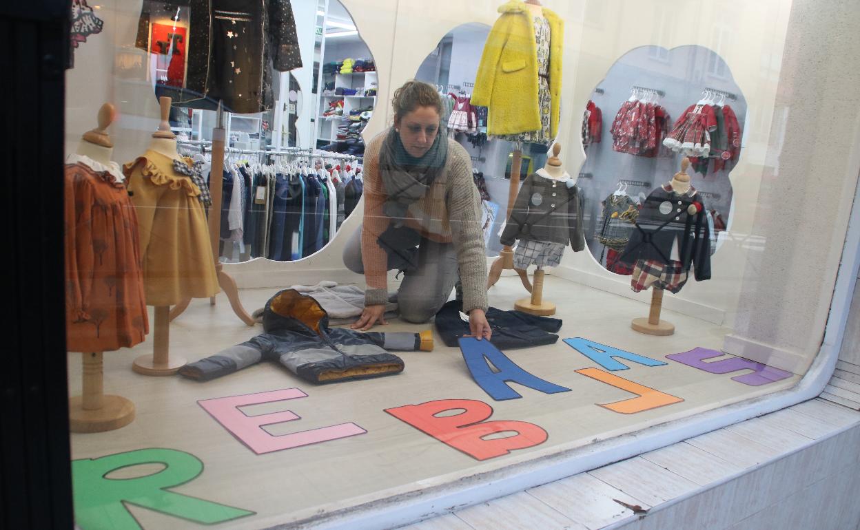 Una comerciante de Solares coloca su cartel en las rebajas de comienzo del año pasado 