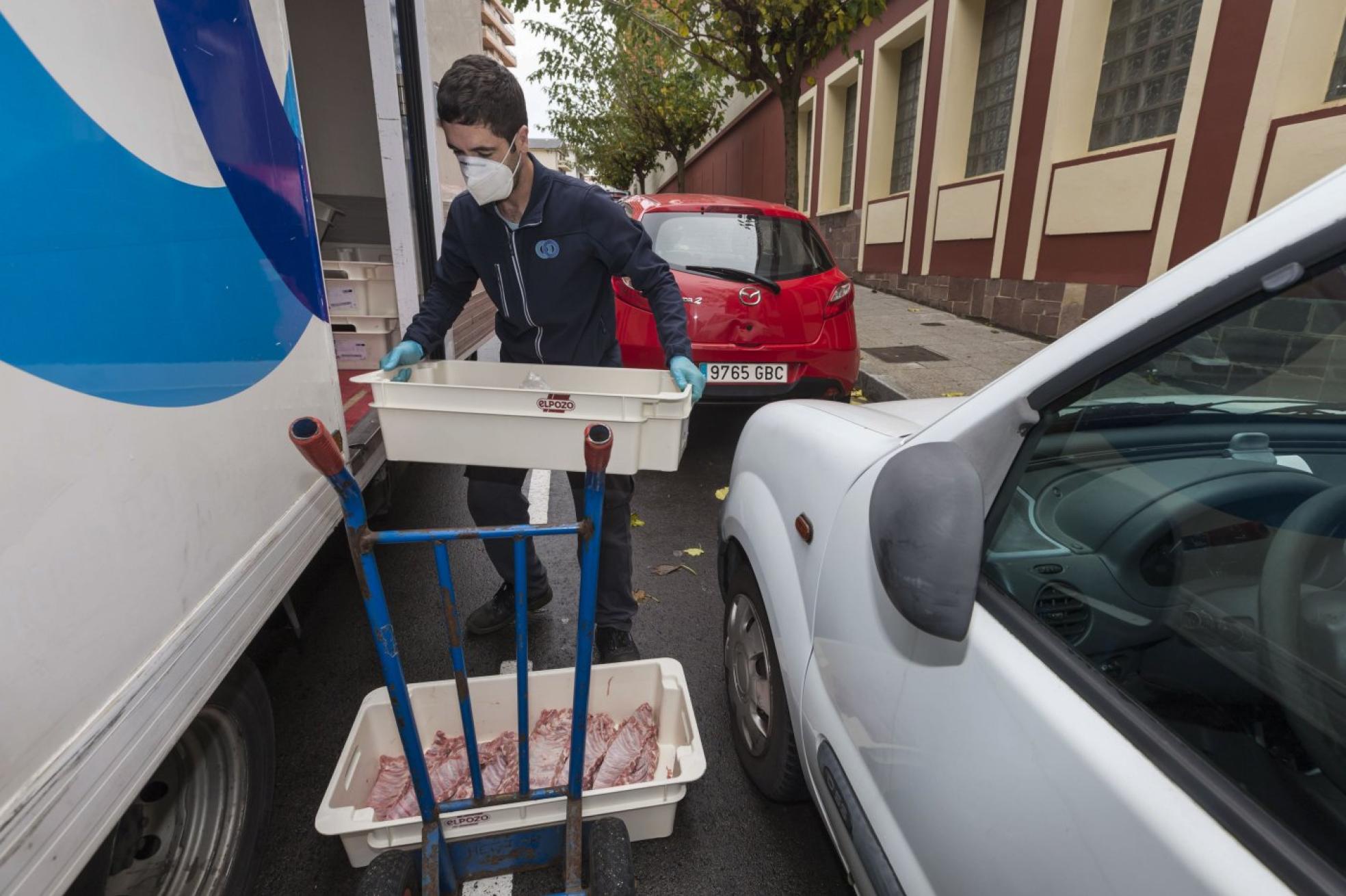 Un trabajador descarga el camión de comida.