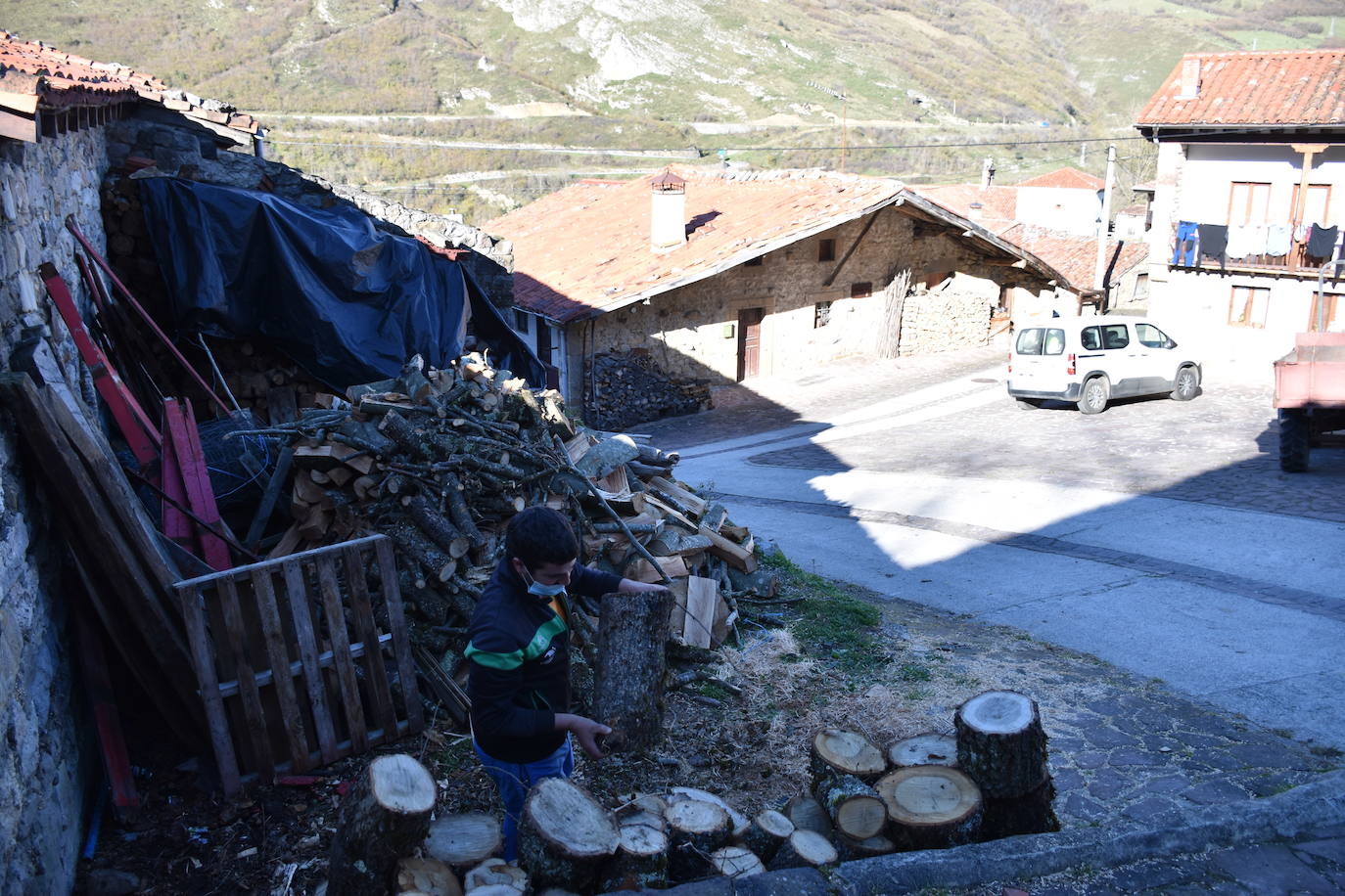 Javier Fernández, hace la leña a las puertas de su casa en Tudanca, que este domingo estaba prácticamente vacío.