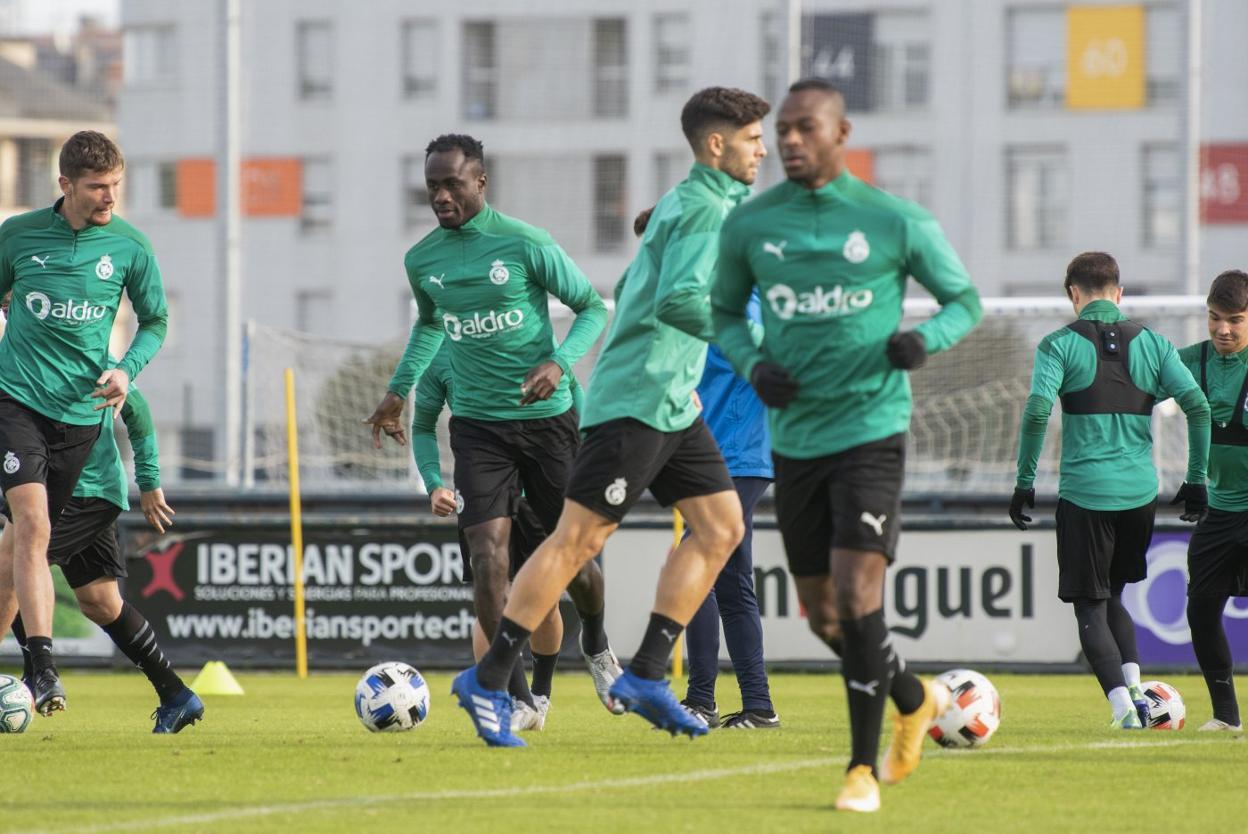  Varios jugadores del Racing conducen el balón durante la sesión de entrenamiento de ayer en La Albericia. 