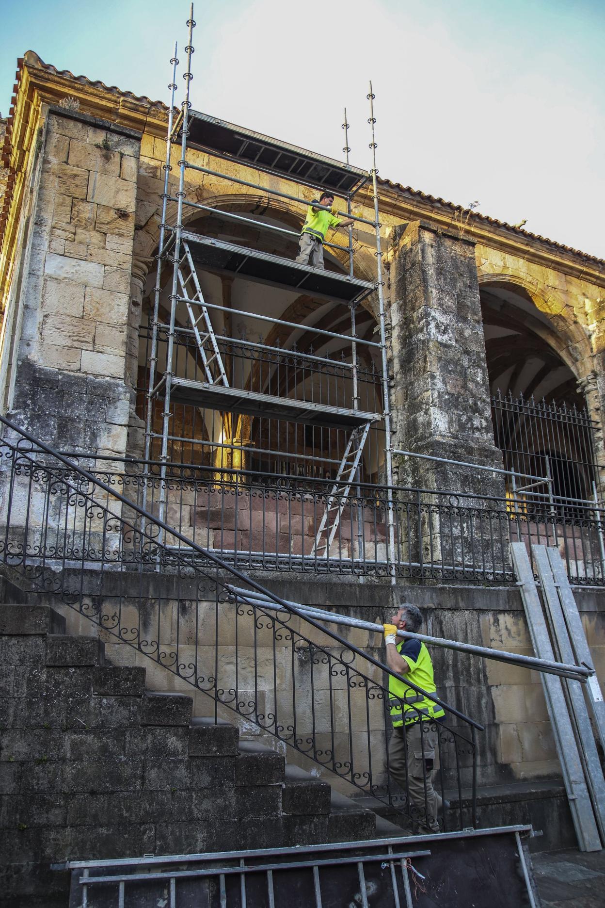 Dos operarios de la empresa Canalsa colocan los primeros andamios en el exterior de la iglesia. a. verano